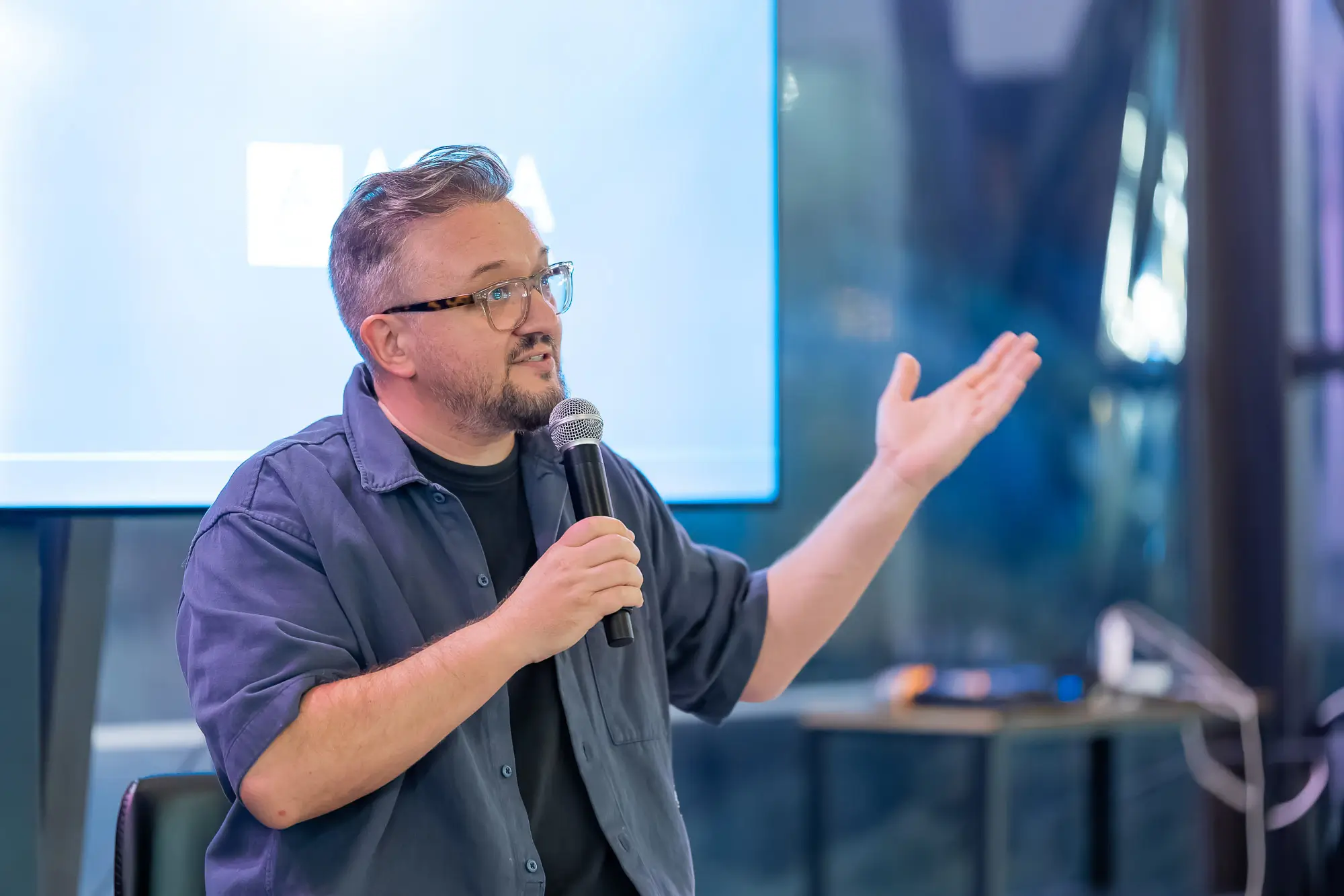Florin Grozea speaking into a microphone during a conference presentation